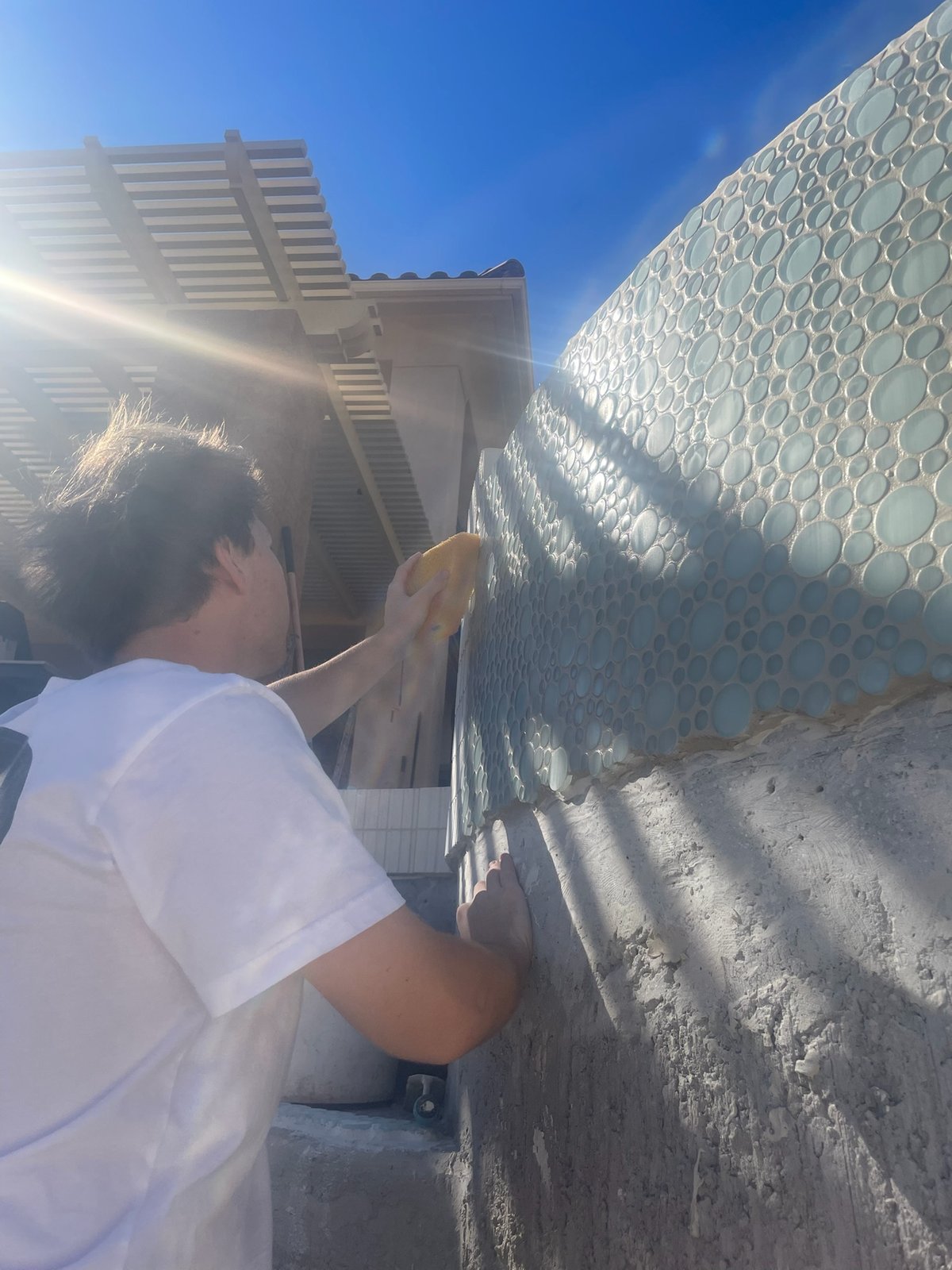 Custom glass tile installation on pool wall